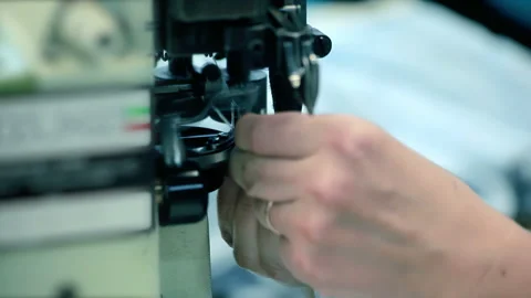 Seamstress hands stitching white fabric industrial sewing machine. Closeup work. Stock Footage 345919923