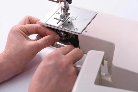 The seamstress inserts the bobbin into the sewing machine. Foto stock