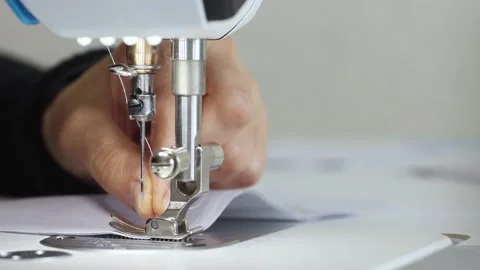 Seamstress inserts thread in needle of sewing machine, side view. Stock Footage 166117811