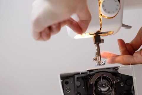 Seamstress inserts thread in sewing-machine 스톡 사진