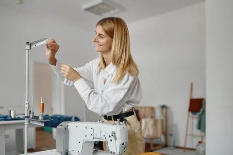 Seamstress inserts thread into the sewing machine Stock Photos