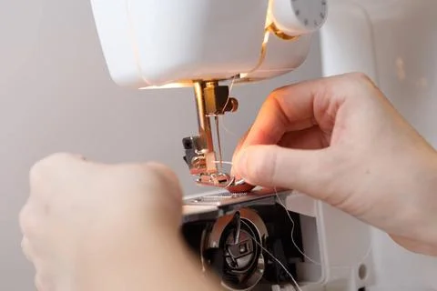 Seamstress inserts thread in sewing-machine Seamstress inserts thread in s... Stock Photos