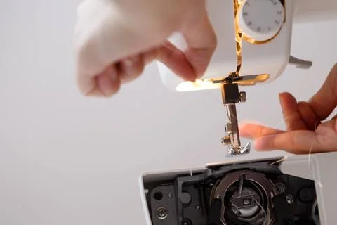 Seamstress inserts thread in sewing-machine Seamstress inserts thread in s... Foto stock