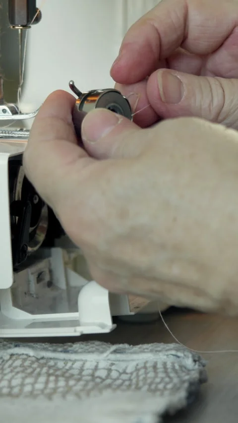 Seamstress installing bobbin case into sewing machine Stock Footage 327371911