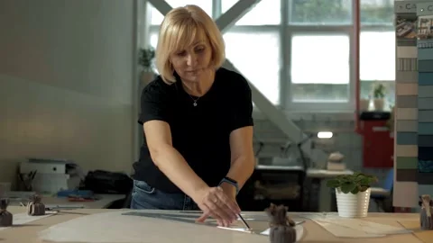 Seamstress looking for inspiration creates a clothing line using patterns Stock Footage 179701853