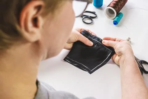 Seamstress makes a pattern out of fabric, basting the piece with pins Stock Photos