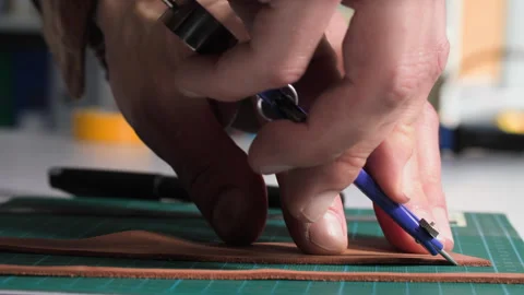 Seamstress, male tailor using tools for pattern and sewing cuts a piece of Stock Footage 246878058