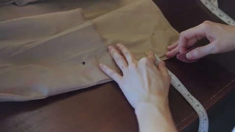 Seamstress marks a pattern on beige fabric Stock Footage 111545538