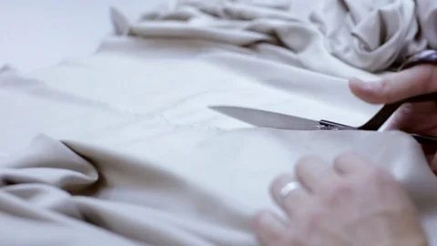 Seamstress neatly cuts fabric with scissors Stock Footage