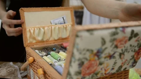Seamstress opens box with thread and begins to threading overlock Stock Footage 74154880
