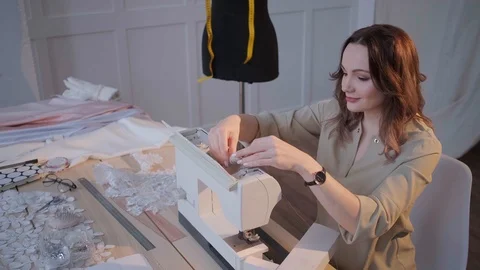 A seamstress prepares a sewing machine to work. In the background mannequin Stock Footage 126859369