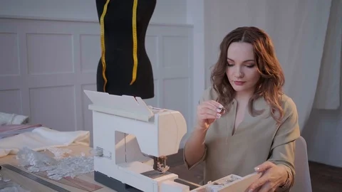 A seamstress prepares a sewing machine to work. In the background mannequin Stock Footage 126859414