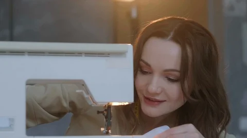 A seamstress prepares a sewing machine to work. In the background mannequin Stock Footage 127015757