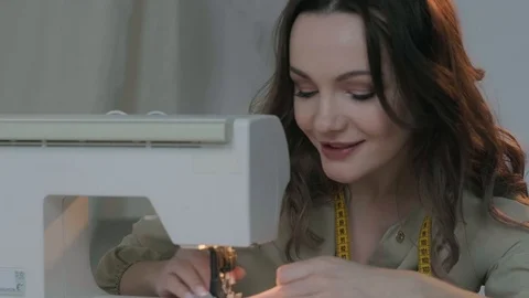 A seamstress prepares a sewing machine to work. In the background mannequin Stock Footage 127363067