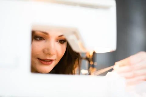 Seamstress pulls the thread on a sewing machine to complete the order Stock Photos