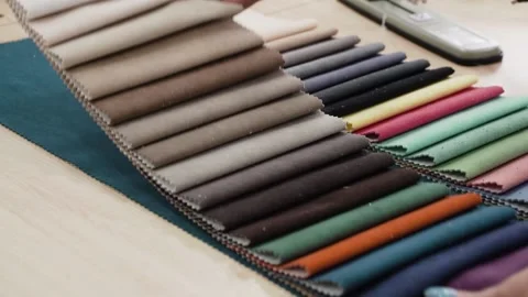 Seamstress puts samples of sewn multi-colored fabrics Stock Footage 183459227