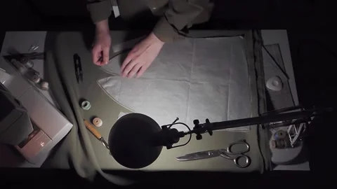 The seamstress removes the needles pinned to the pattern, top view. Stock Footage 149207423