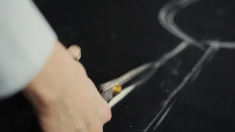 Seamstress with scissors cutting fabric Видео 82931215