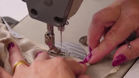 Seamstress sew fabric on an sewing machine slow motion Stock Footage