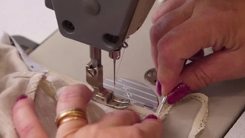 Seamstress sew fabric on an sewing machine slow motion Stock Footage