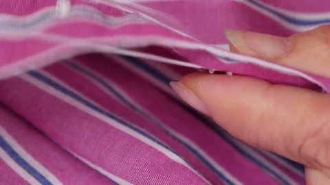 Seamstress Sewing a Button on a Shirt Closeup Stock Footage 80558202