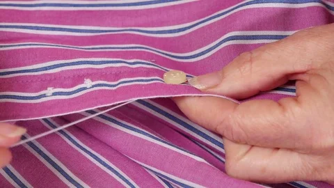 Seamstress Sewing a Button on a Shirt Stock-Footage 80558288