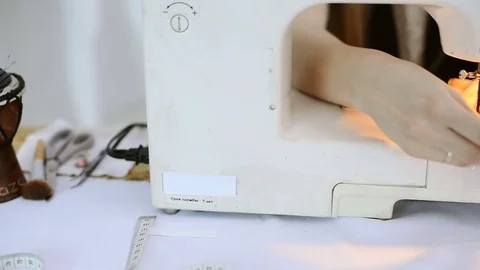 Seamstress on sewing machine scribbling piece of pink fabric Stock Footage 73288093
