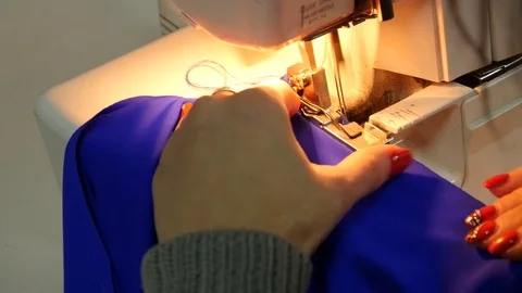 Seamstress sews Clothes using a Sewing Machine Stock Footage 123654976