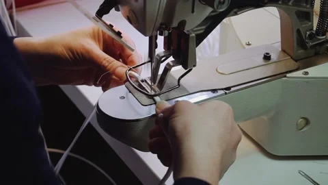Seamstress sews white laces with machine in workshop Stock Footage 236908696
