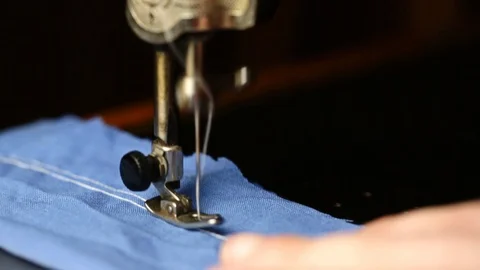 The seamstress sews with a white thread on an old sewing machine a blue clot 스톡 동영상 128800482