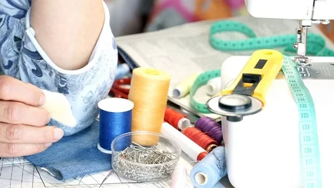 Seamstress sitting by the table in her studio and holding white chalk Stock Footage 78557782