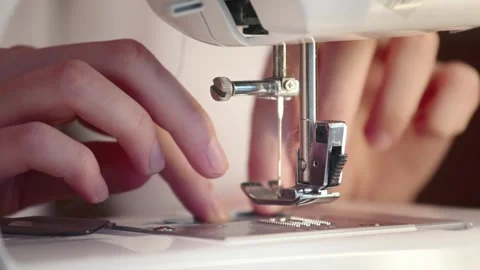 The seamstress slips a thread into the needle eye of a sewing machine, fingers Stock Footage 269808576