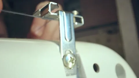 The seamstress slips a thread into the needle eye of a sewing machine, fingers Stock Footage 269811498