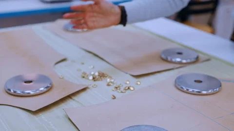 Seamstress spreading buttons on sewing pattern Vídeos de archivo 335932429