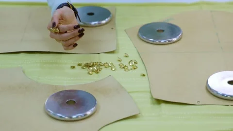 Seamstress spreading buttons on sewing pattern Vidéo 336247331