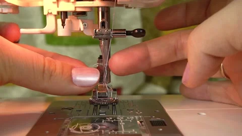 A seamstress is threading the eye of a needle with a needle threader. Stock Footage 139232967