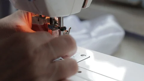 Seamstress threading a needle in a sewing machine Stock Footage 128244451