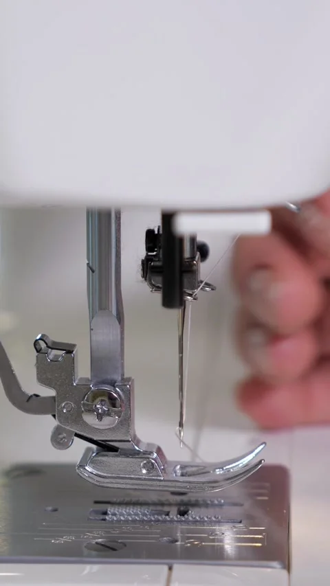 Seamstress threading a sewing machine needle, skilled dressmaker preparing 库存影片 341442954