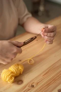 The seamstress threads the thread into a large sewing needle Stock Photos