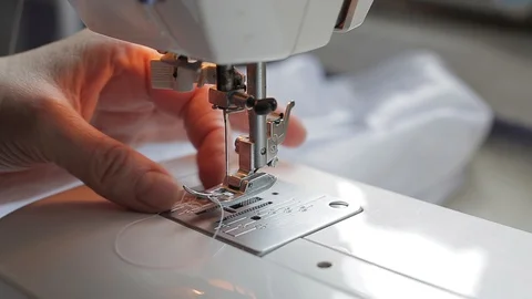 Seamstress try threading a needle in a sewing machine Stock Footage 128244088