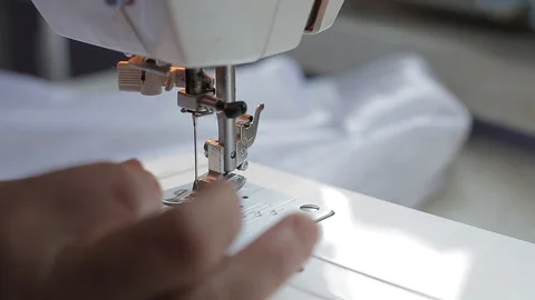 Seamstress try threading a needle in a sewing machine Stock Footage 128244377