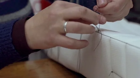 Seamstress tying knots on strings Stock-Footage 70391598
