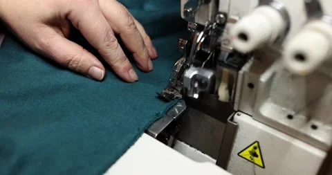 Seamstress uses overlock machine to secure fabric edges Video stock 272914021