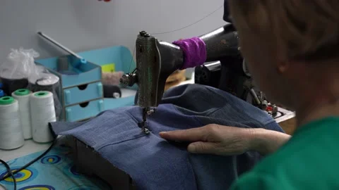 Seamstress work from behind the shoulder, home production, tailor works Stock Footage 223383067