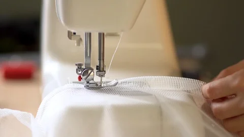 Seamstress at work. The process of hemming the edges of curtains from white mesh Stock-Footage 127024067