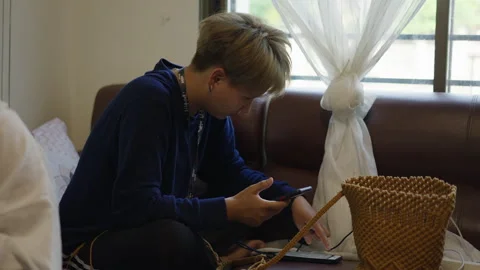 Seamstress writes something on her mobile phone while looking at the other one Video stock 246590562