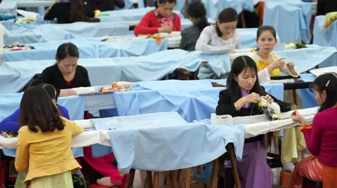 Seamstresses are embroidering patterns on clothes under lamps in clothing Stock Footage 67425329