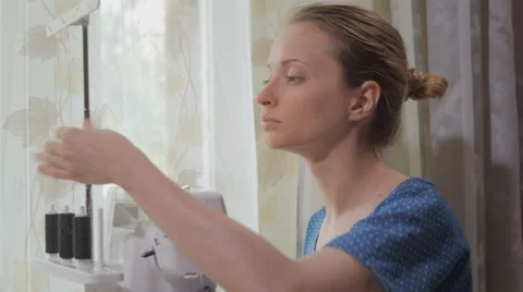 Seamstresses is refilling threads and tuning an overlock Video stock 64605181