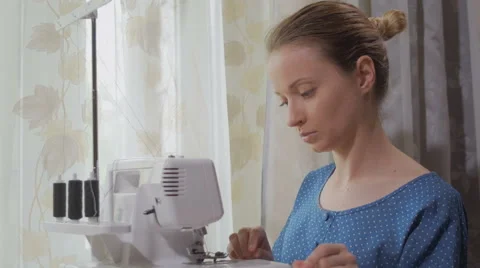 Seamstresses is refilling threads in overlock and cutting it Video stock 64605405