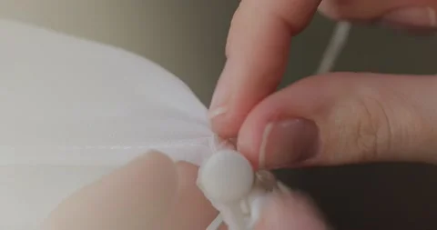 Seamstress's hands sew button with  needle thread cut the thread with scissors Stock Footage 171609613